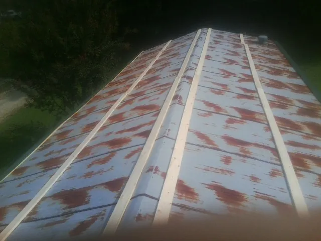 Rusted metal roof panels with new wood purlins before replacement — Storm Damage Roof Repair in Orleans by Roofing Brothers